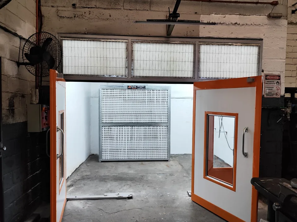 Cabine de pintura laranja com portas abertas