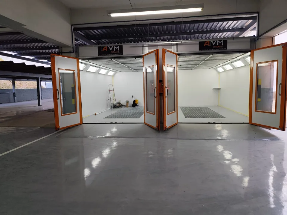 Cabine de pintura com portas abertas em oficina